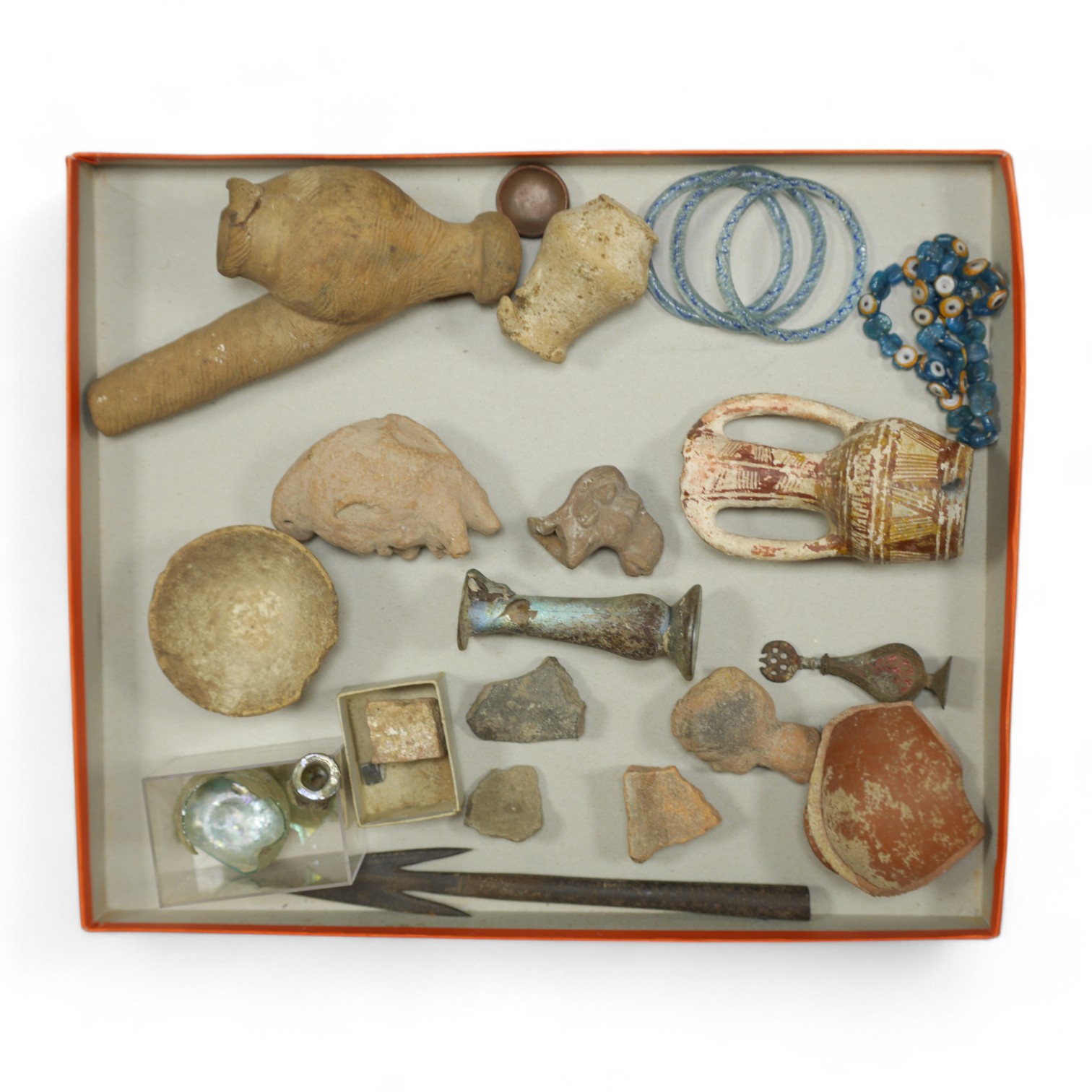 A collection of Roman, Ancient Greek and other items, including a glass vial, a broken glass bottle, a two handled pottery vase, shards of pottery items, a pottery figure head and other pottery items, an iron spear head,